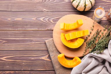 Tahta arka planda taze balkabağı parçaları olan tahta.