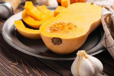 Ahşap zemin üzerinde taze kabak parçaları olan bir tabak.