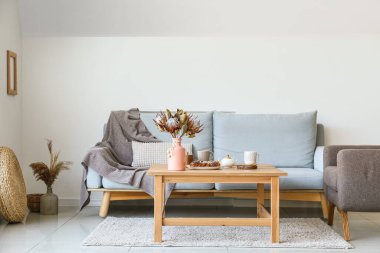 Rahat kanepesi, koltuğu ve masası olan modern bir oturma odası.