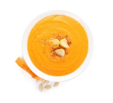 Beyaz arka planda balkabağı kremalı çorba.