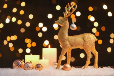 Altın ren geyiği, Noel baloları ve kar masasında yanan mumlar.