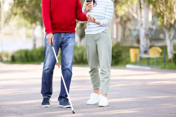 Blind man with his daughter walking outdoors