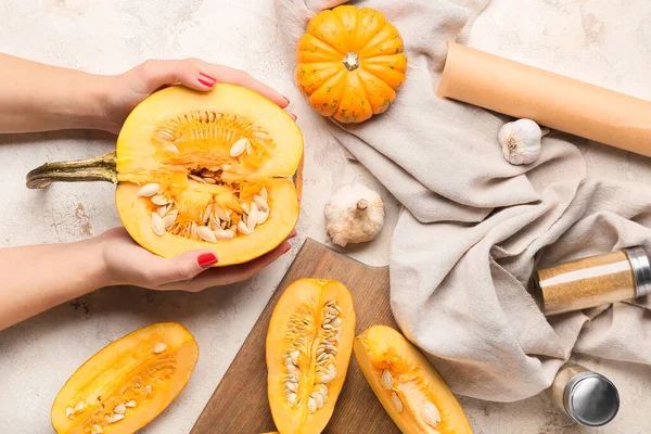 Hafif arka planda taze kabak parçaları olan kadın eller.