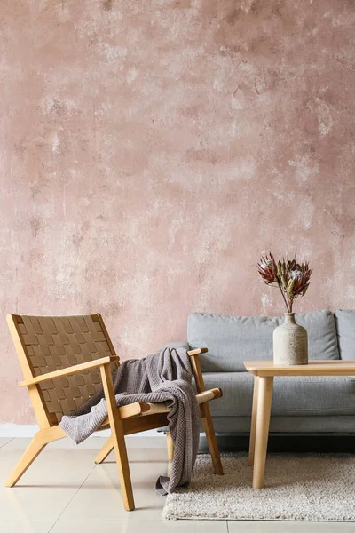 Rahat koltuk, kanepe ve vazo renkli duvarın yanında.