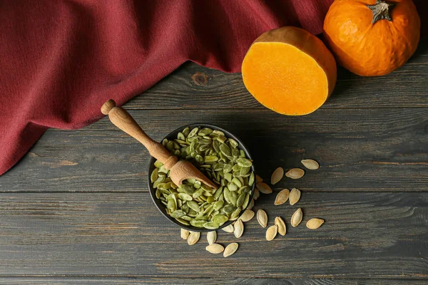 Ahşap zemin üzerinde kabak tohumları olan bir kase