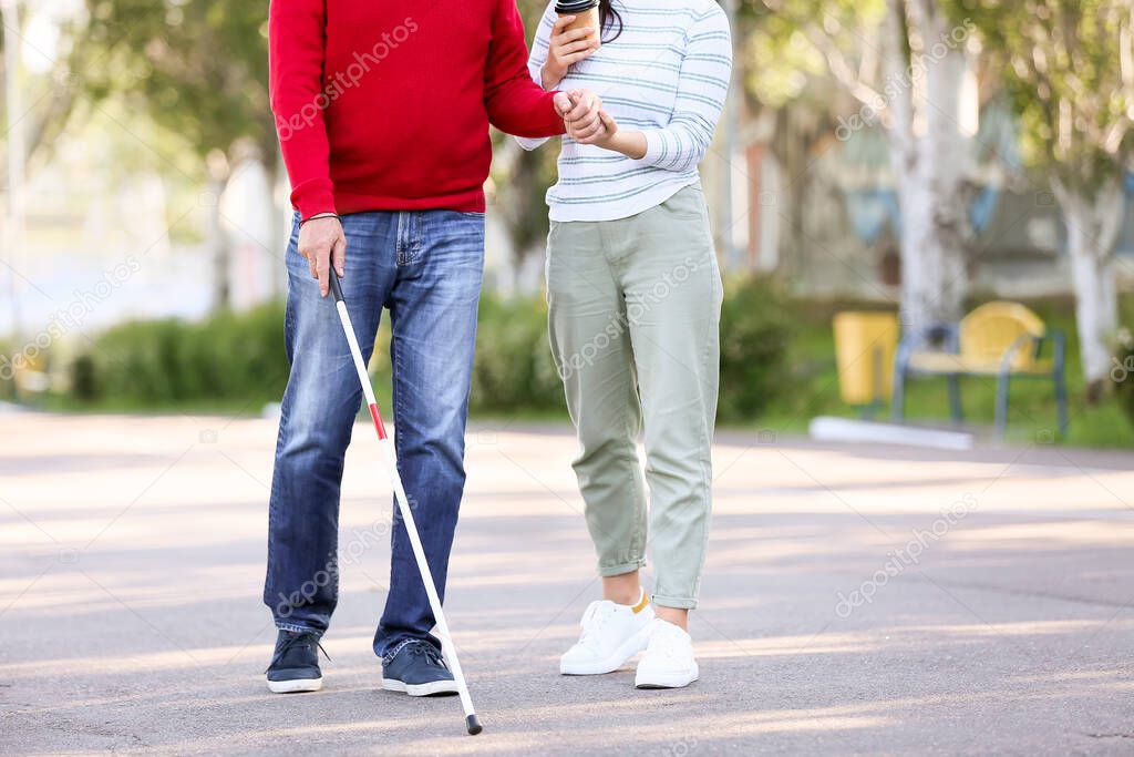 Blind man with his daughter walking outdoors