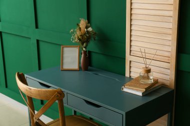 Yeşil duvarın yanında işyeri olan şık bir ev.