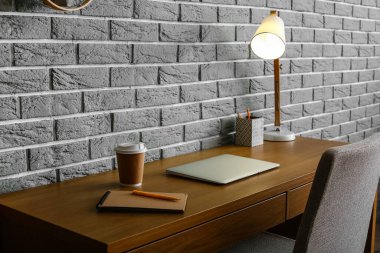 Odanın içindeki tuğla duvarın yanında rahat bir iş yeri.