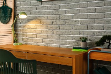 Odanın içindeki tuğla duvarın yanında rahat bir iş yeri.