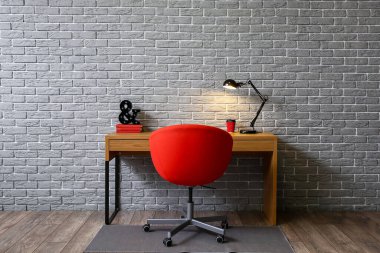 Odanın içindeki tuğla duvarın yanında rahat bir iş yeri.