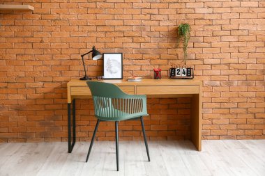 Kahverengi tuğla duvarın yanında rahat bir iş yeri.