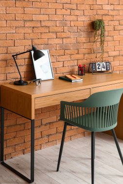 Kahverengi tuğla duvarın yanında rahat bir iş yeri.