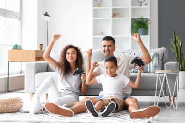 Evde video oyunu oynayan mutlu ırklar arası aile.