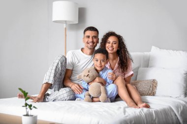 Yatak odasında mutlu ırklar arası aile.
