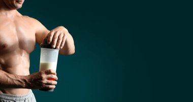 Siyah arka planda protein içeceği olan erkek vücut geliştirici.