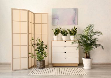 Odanın içindeki duvarın yanındaki katlama ekranı çok şık.