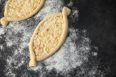 Ev yapımı Ajarian Khachapuri karanlık masa arka planında pişirmeye hazırlanıyor.