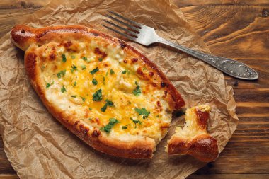 Masa arkasında lezzetli Ajarian khachapuri