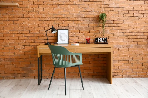 Kahverengi tuğla duvarın yanında rahat bir iş yeri.