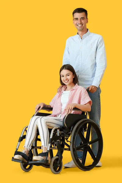 坐在轮椅上的年轻女子和她的肤色背景丈夫 — 图库照片