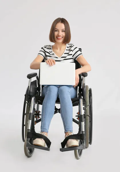 Młoda Kobieta Wózku Inwalidzkim Przy Użyciu Laptopa Jasnym Tle — Zdjęcie stockowe