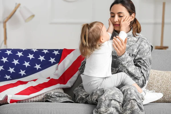 アメリカ軍の女性兵士と彼女の小さな娘座っていますソファに家に — ストック写真