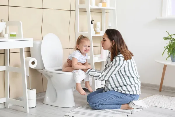 女は赤ん坊にトイレのボウルを使うように教えている — ストック写真