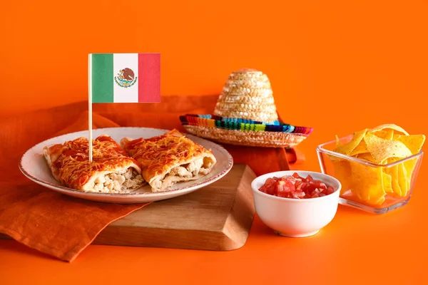 メキシコの伝統的な食べ物はオレンジの背景に旗で飾られています — ストック写真