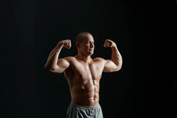 Man Bodybuilder Mörk Bakgrund — Stockfoto