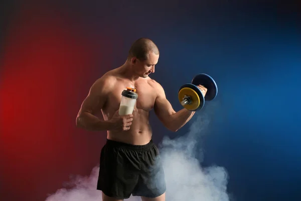Protein Içeceği Koyu Arkaplanda Dambılı Olan Erkek Vücut Geliştirici — Stok fotoğraf