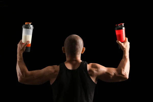 Man Bodybuilder Med Protein Shakes Mörk Bakgrund Baksida — Stockfoto