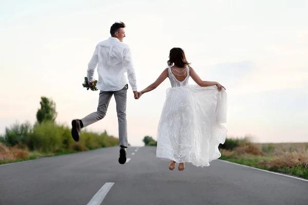 Feliz Boda Pareja Saltando Carretera Campo — Foto de Stock