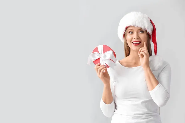 Mujer Joven Reflexiva Sombrero Santa Con Regalo Navidad Sobre Fondo —  Fotos de Stock
