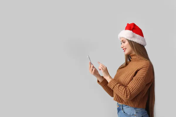 Чудова Молода Жінка Санта Каті Мобільний Телефон Сірому Фоні — стокове фото