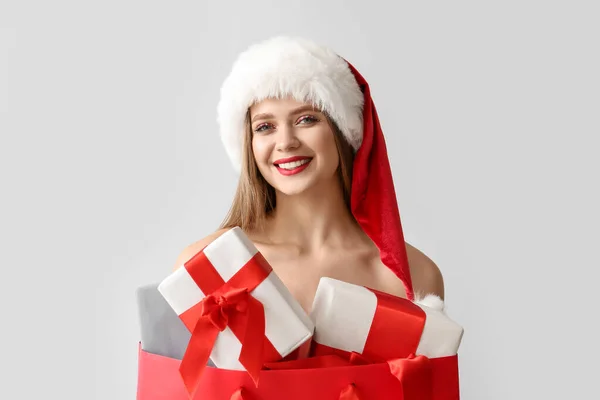 Όμορφη Νεαρή Γυναίκα Σάντα Καπέλο Και Δώρα Χριστουγέννων Γκρι Φόντο — Φωτογραφία Αρχείου