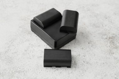 Kamera pilleri ve şarj aleti arka planda