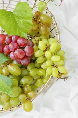 Beyaz kumaşlı olgun üzümlü sepet.