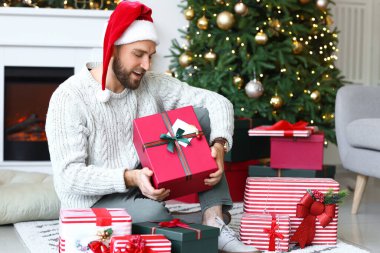 Noel arifesinde evde hediyeleri olan yakışıklı adam.