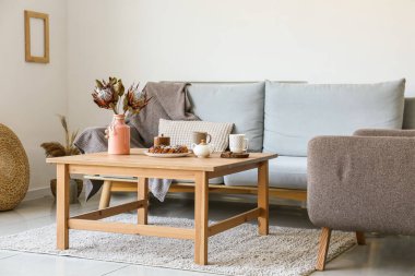 Oturma odasındaki kanepede fırın ve fincanla bir masa.