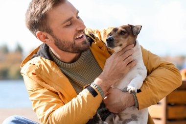Sonbahar günü komik Jack Russel teriyeri olan yakışıklı bir adam.