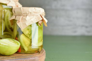 Yeşil ahşap arka planda konserve domatesli kavanozlar