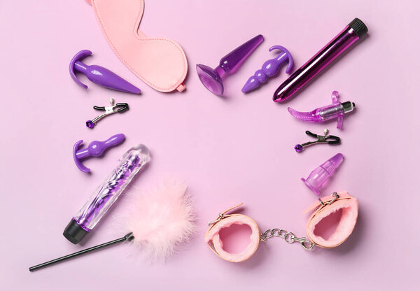 Рамка из игрушек из секс-шопа на цветном фоне