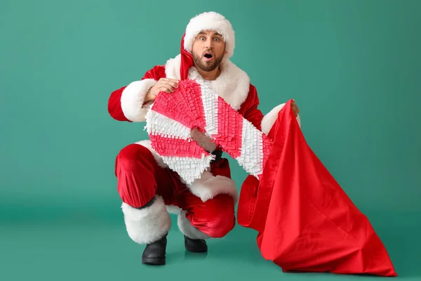 Szokujące Santa Claus Biorąc Pinata Trzciny Cukrowej Torby Zielonym Tle — Zdjęcie stockowe