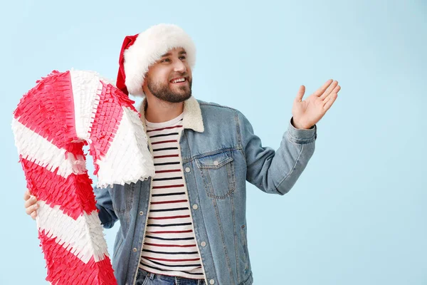 Schöner Mann Mit Weihnachtsmütze Und Zuckerstange Pinata Zeigt Etwas Auf — Stockfoto