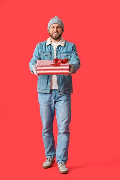 Schöner Mann Mit Weihnachtsgeschenk Auf Farbigem Hintergrund — Stockfoto