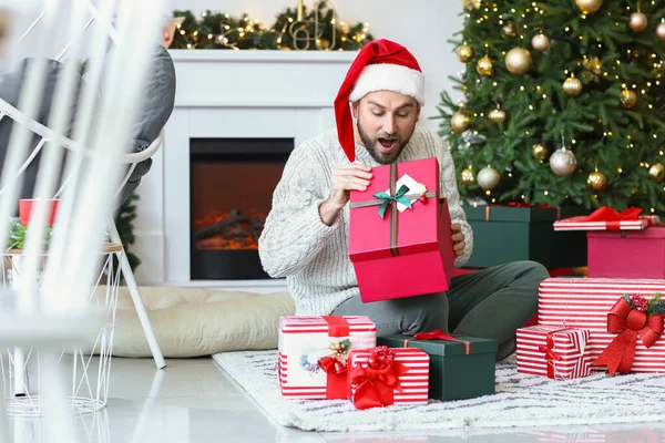 Handsome Man Opening Christmas Gifts Home — Stock Photo, Image