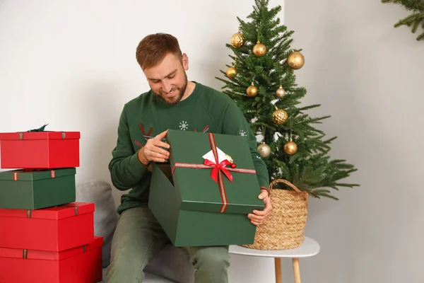 Bonito Homem Abrindo Presentes Natal Casa — Fotografia de Stock