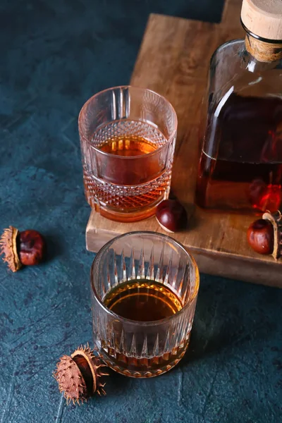 黒を基調とした栗のウイスキーとボトルのグラス — ストック写真
