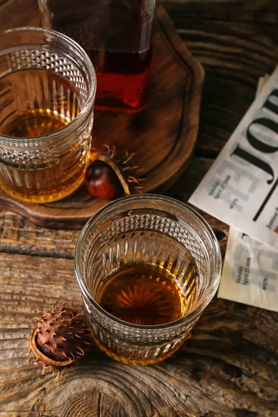 木の背景に栗のウイスキーのグラス — ストック写真