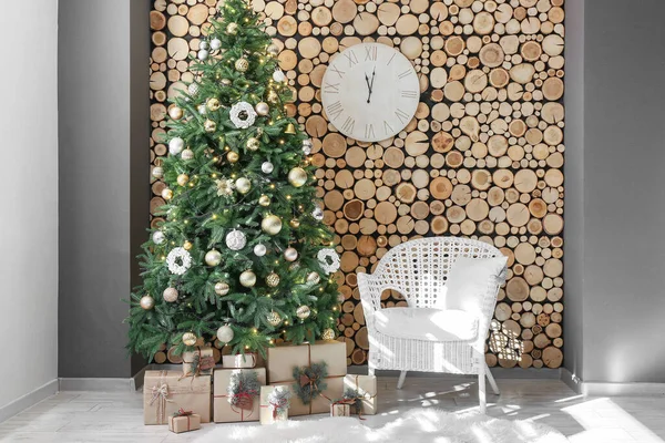 Schöner Weihnachtsbaum Mit Geschenken Und Weißem Sessel Nahe Der Holzwand — Stockfoto
